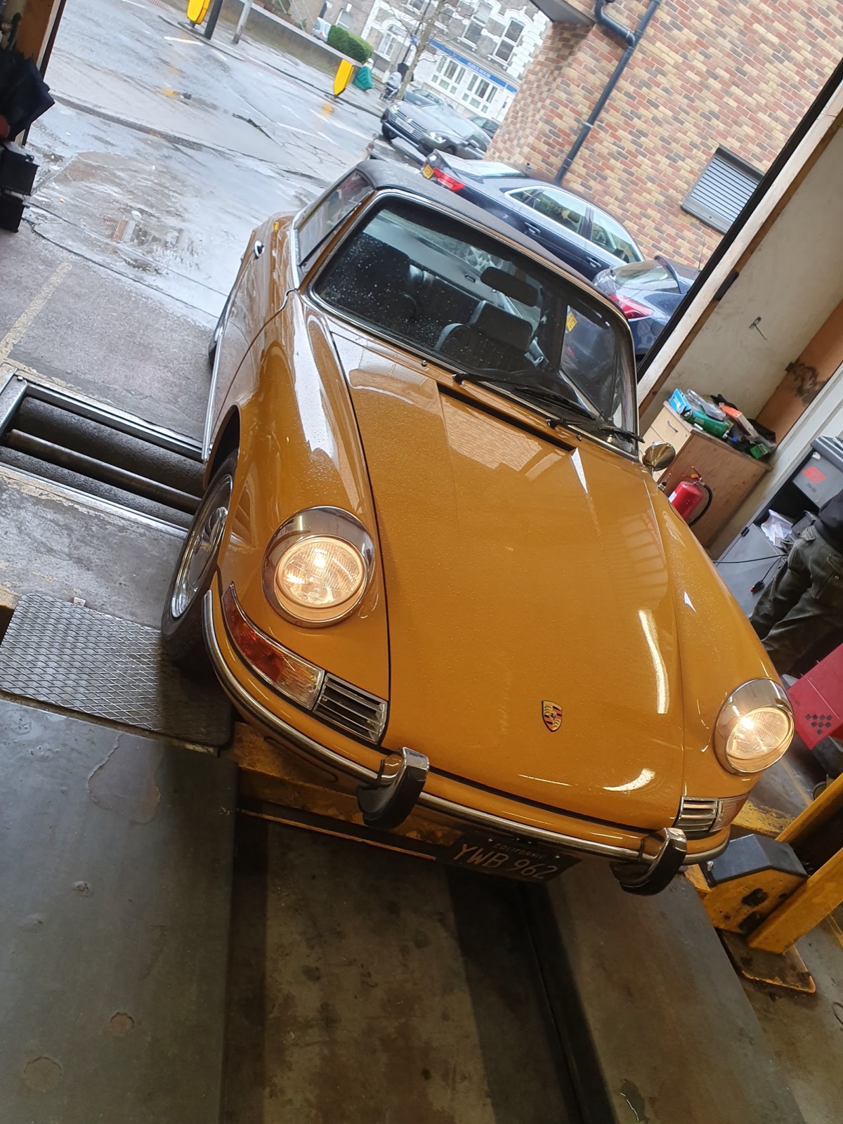 A car raised on the ramp inside the General Autos workshop bay